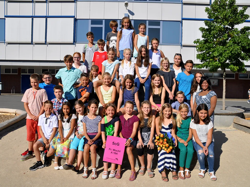 Klassenfoto einer neuen fünften Klasse mit rosafarbenen Namensschildern.